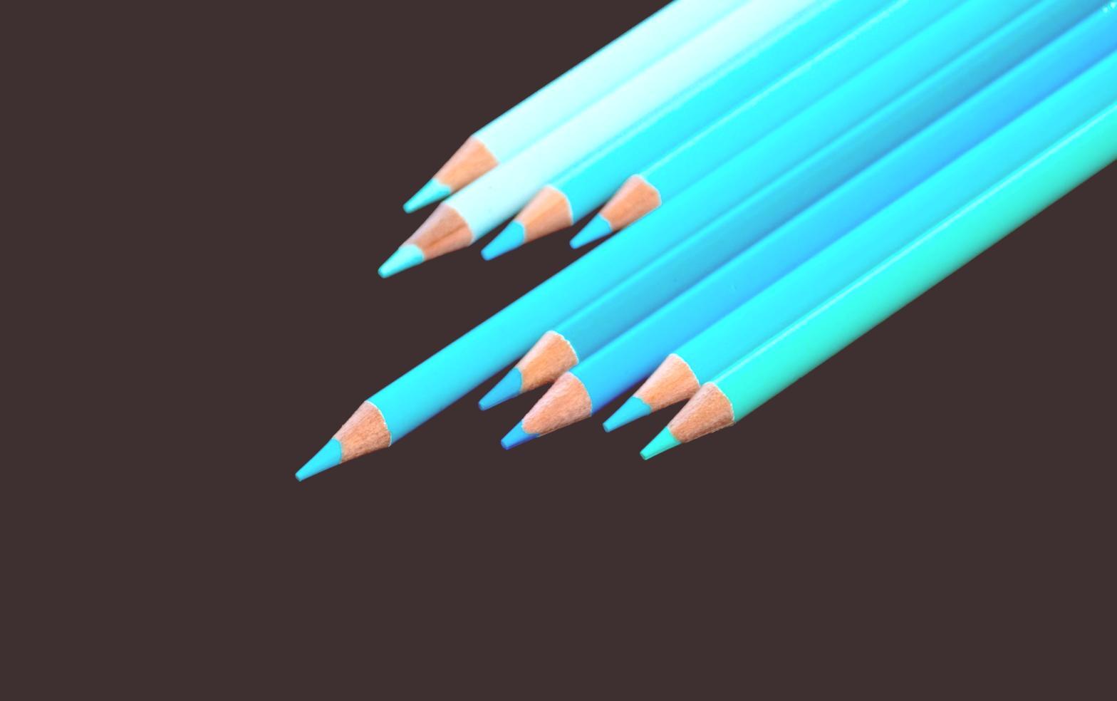 Dettaglio di mani che disegnano su carta con matite colorate